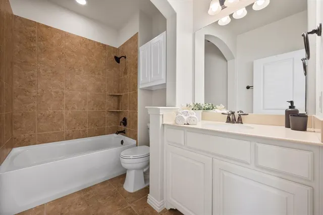 a bathroom with a tub a sink and a large mirror