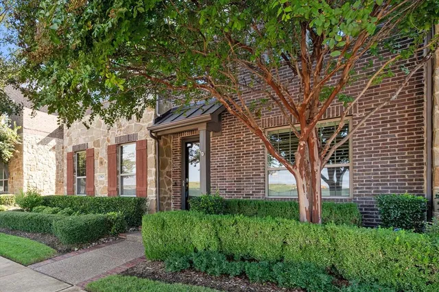 a front view of a house with a tree