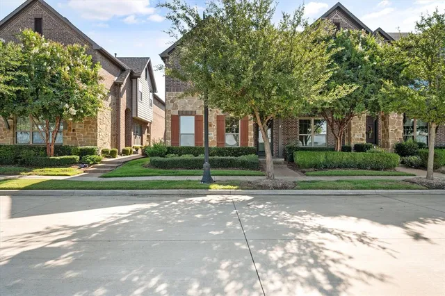 a view of a house with a big yard and large trees