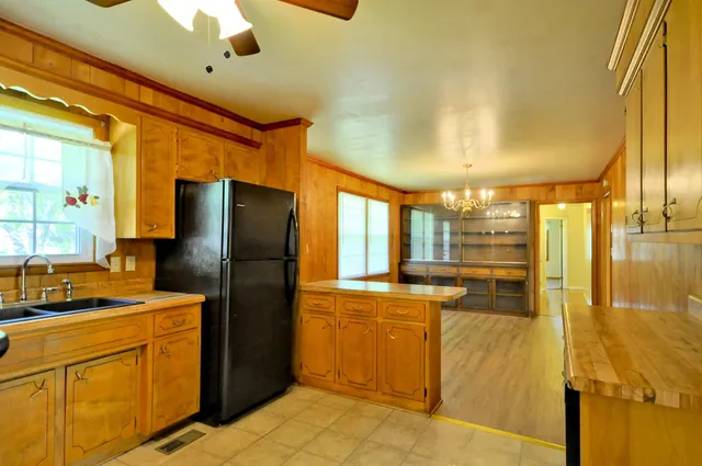 a kitchen with stainless steel appliances granite countertop a refrigerator a stove and a sink with cabinets