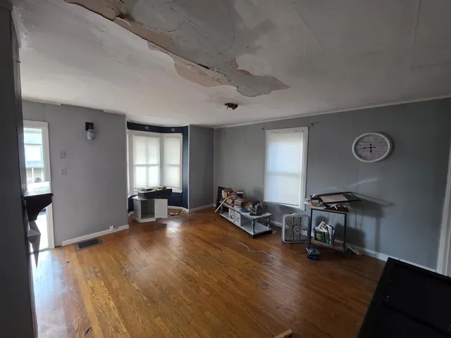 a view of a livingroom with lounge chair and a window