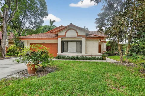 a front view of a house with a garden and yard