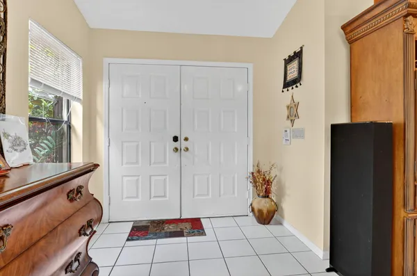 a living room with furniture and a dining table with kitchen appliances