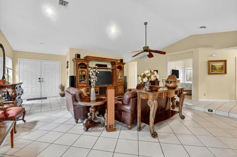 a living room with furniture a window and a ceiling fan
