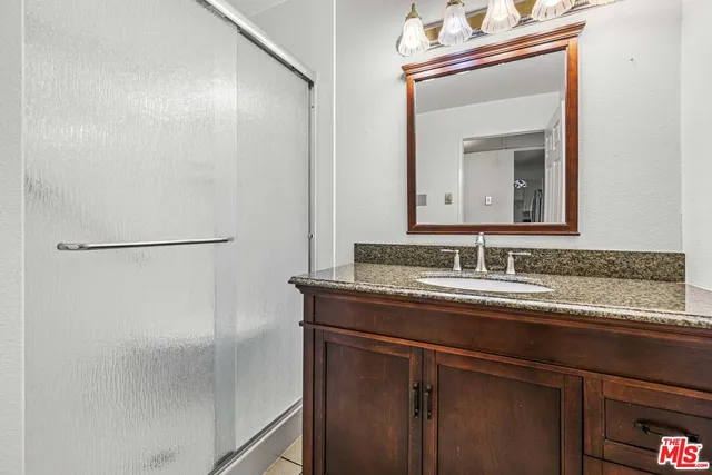 a bathroom with a granite countertop sink and a mirror