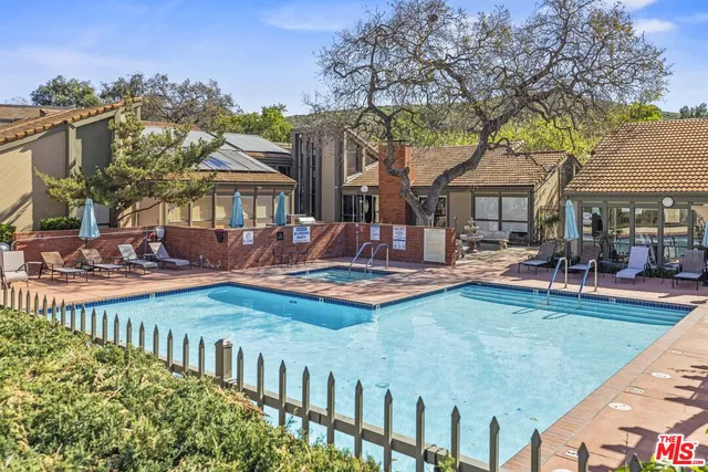 a view of a house with swimming pool and sitting area