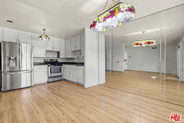a kitchen with granite countertop stainless steel appliances and wooden cabinets