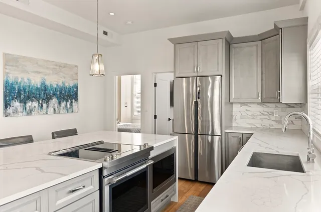 a kitchen with granite countertop a sink stove and refrigerator