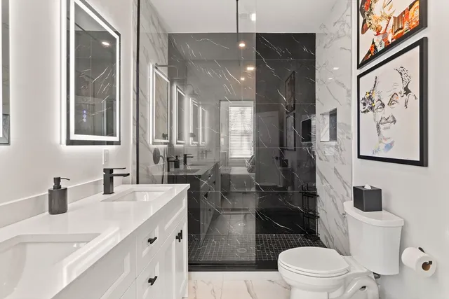 a bathroom with a sink a toilet and shower