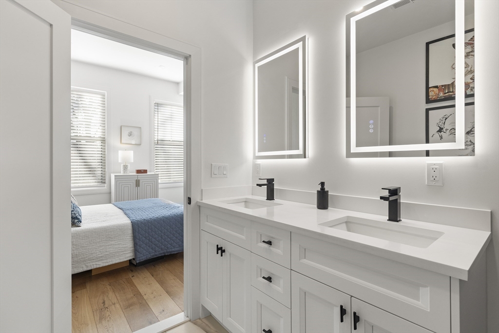 157 Princeton Street, Unit 2 Boston, MA 02128 - Photo 18 of 22 a en suite bathroom with a double vanity sink a mirror and next to a window