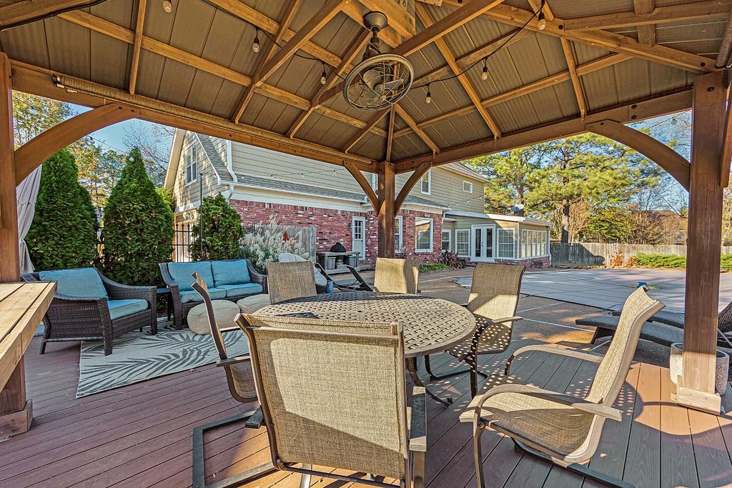 1213 Heather Ridge Cove Collierville, TN 38017 - Photo 22 of 25 a view of a patio with table and chairs under an umbrella with a small yard