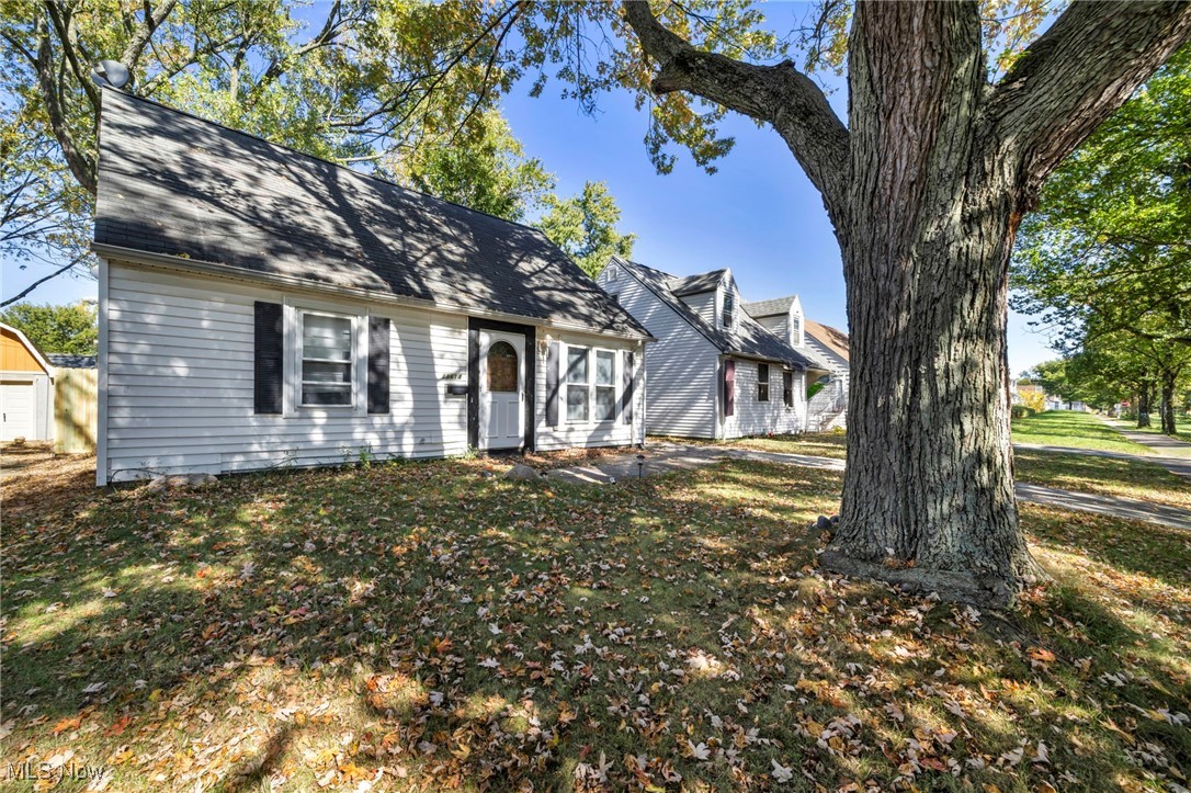 View of front of home featuring a front yard and a shingled roof