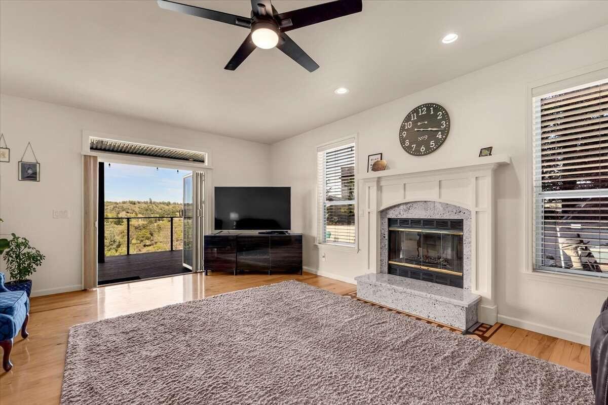 416 Arbor Place Redding, CA 96001 - Photo 7 of 31 a living room with furniture a flat screen tv and a fireplace