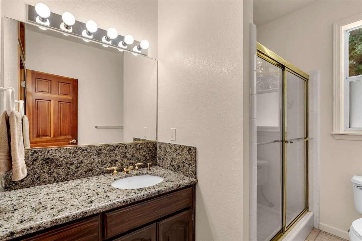 416 Arbor Place Redding, CA 96001 - Photo 9 of 31 a bathroom with a granite countertop sink and a mirror