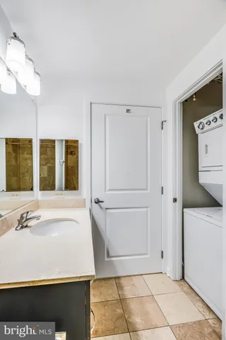 a spacious bathroom with a granite countertop sink a toilet a mirror and bathtub