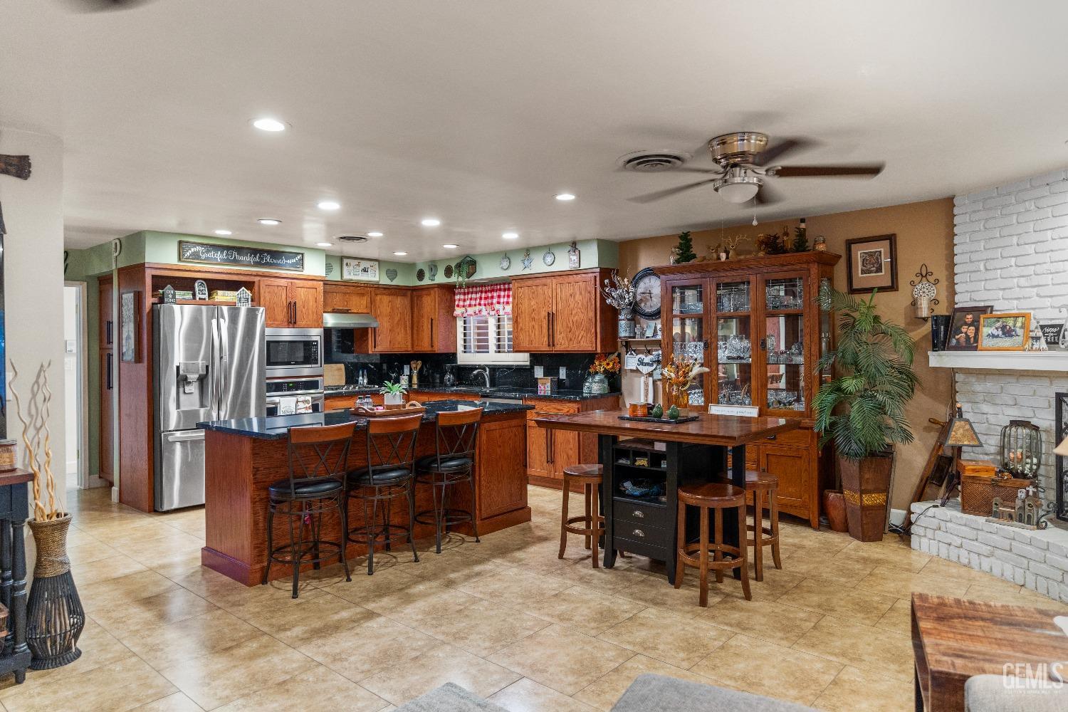 Undisclosed Address Bakersfield, CA 93309 - Photo 9 of 27 a room with lots of wooden furniture a large window and stainless steel appliances