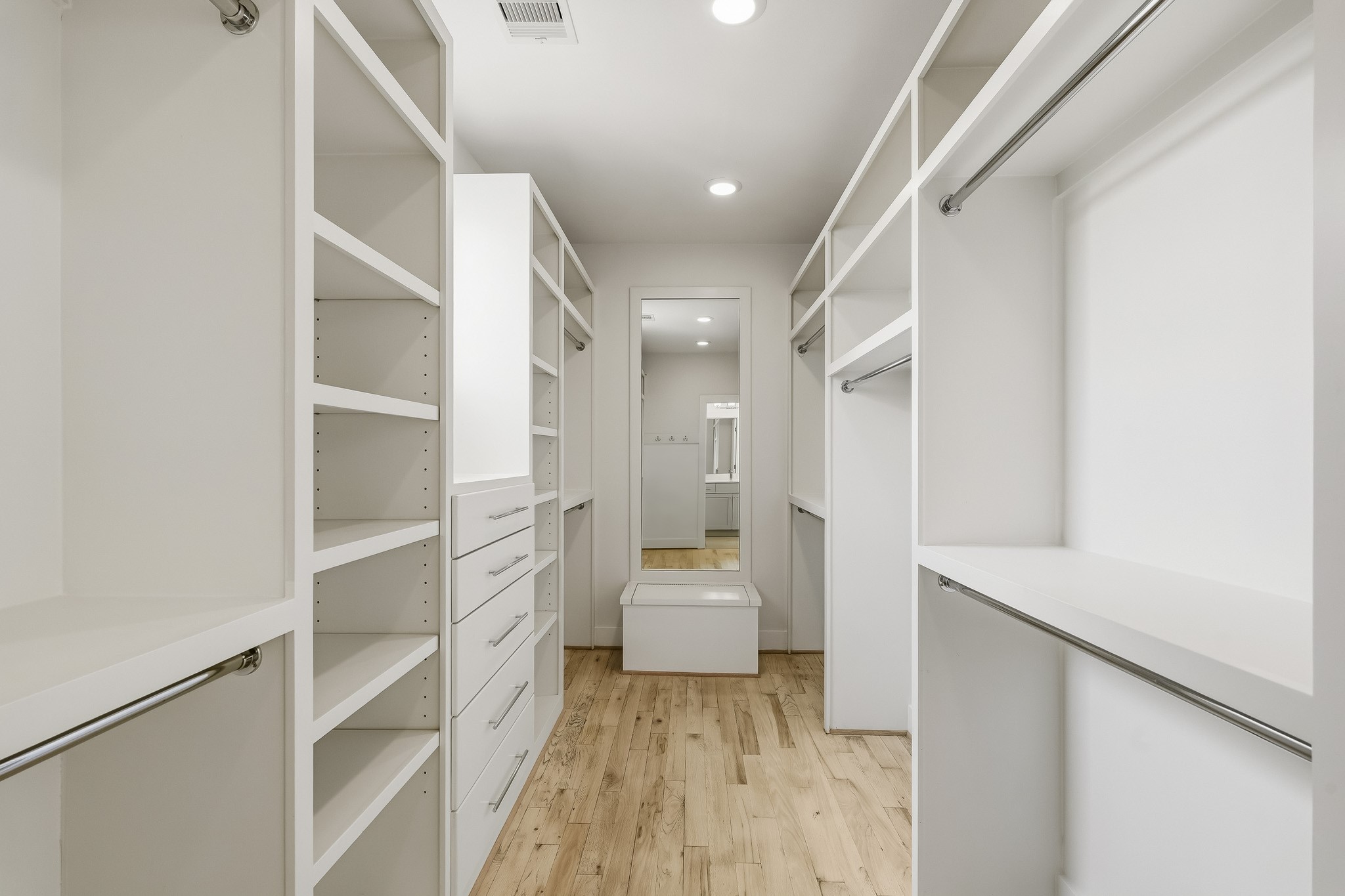 2004 Rosedale Street, Unit D Houston, TX 77004 - Photo 30 of 45 The oversized walk-in closet feels more like a private dressing room, with custom built-in drawers, generous shelving and multiple hanging rods providing exceptional storage and organization. A window fills the space with natural light, while recessed lighting enhances the bright, upscale boutique-style atmosphere.