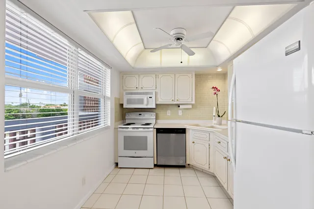 a kitchen with white cabinets white stainless steel appliances and sink