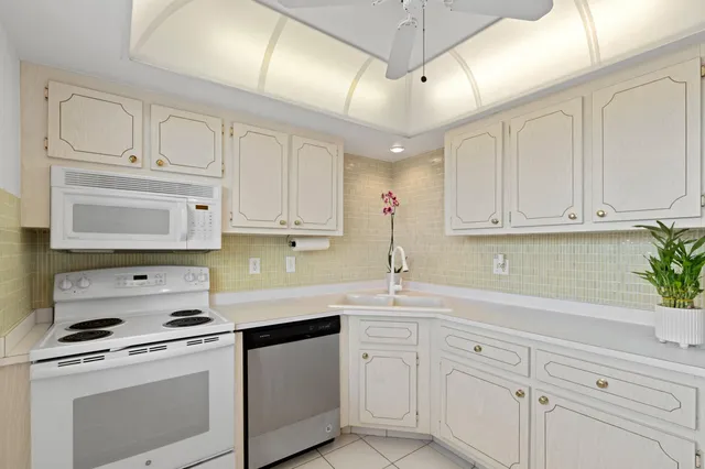 a bedroom with a bed a flat screen tv and dresser next to a window