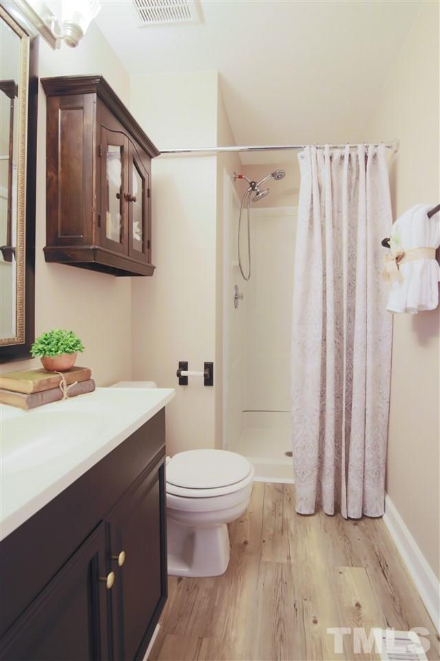 7705 Sandra Lane Raleigh, NC 27615 - Photo 11 of 12 Updated Master bath offers a walk in shower and new flooring.