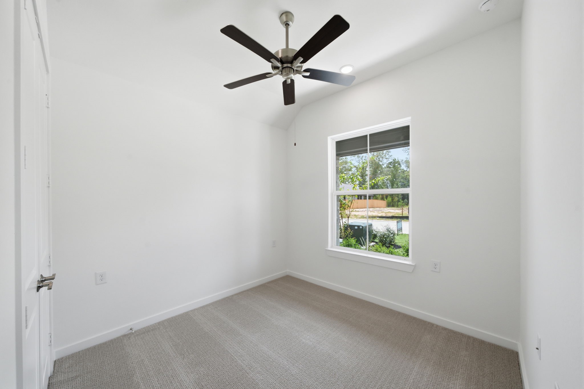 21952 Rolling Grns Road Porter, TX 77365 - Photo 31 of 43 Versatile secondary bedroom with a vaulted ceiling, ceiling fan, and large window—ideal for guests, a home office, or hobby space.