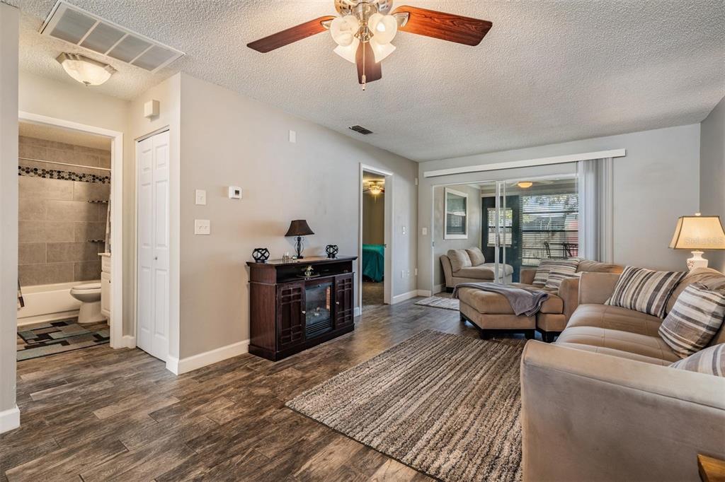 11308 Versailles Lane, Unit C Port Richey, FL 34668 - Photo 11 of 33 a living room with furniture and a fireplace
