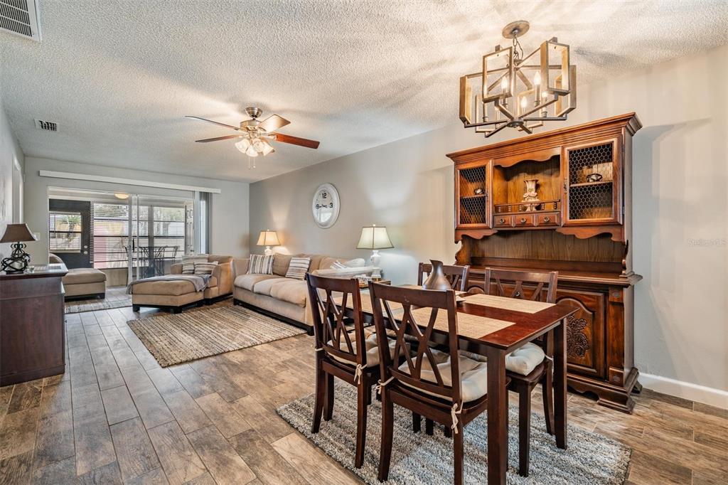 11308 Versailles Lane, Unit C Port Richey, FL 34668 - Photo 13 of 33 a view of a dining room and livingroom with furniture wooden floor a chandelier