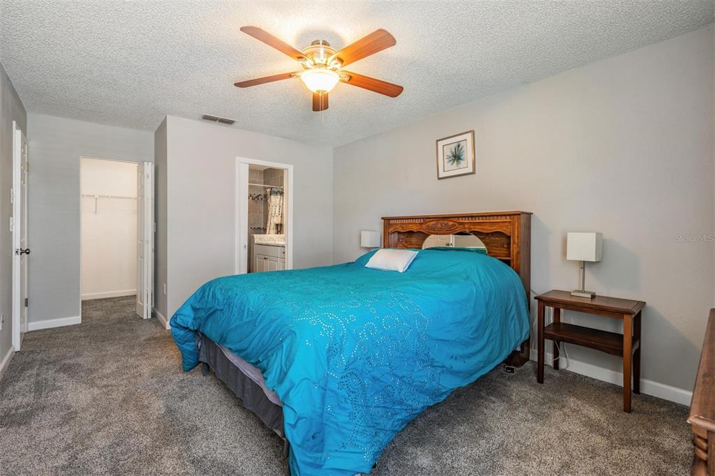 11308 Versailles Lane, Unit C Port Richey, FL 34668 - Photo 14 of 33 a bedroom with a bed and a chandelier