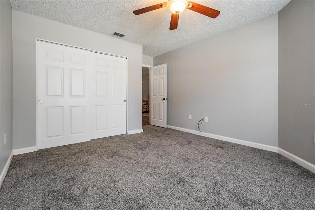 11308 Versailles Lane, Unit C Port Richey, FL 34668 - Photo 20 of 33 an empty room with a ceiling fan and window