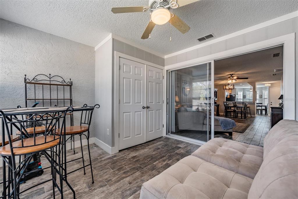 11308 Versailles Lane, Unit C Port Richey, FL 34668 - Photo 22 of 33 a bedroom with furniture and a chandelier