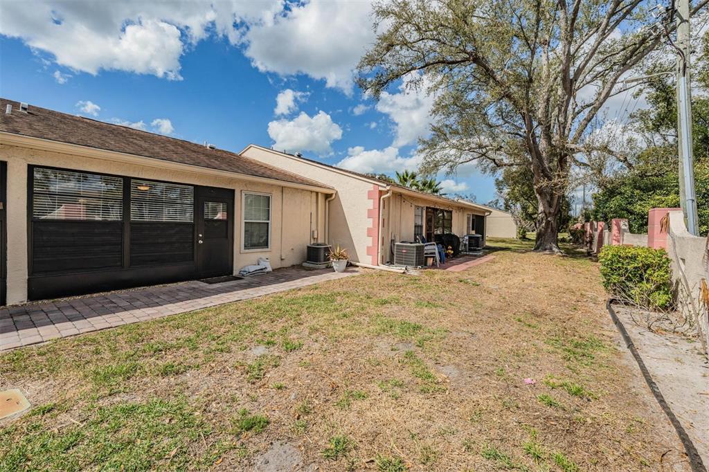 11308 Versailles Lane, Unit C Port Richey, FL 34668 - Photo 26 of 33 a front view of a house with a yard and garage