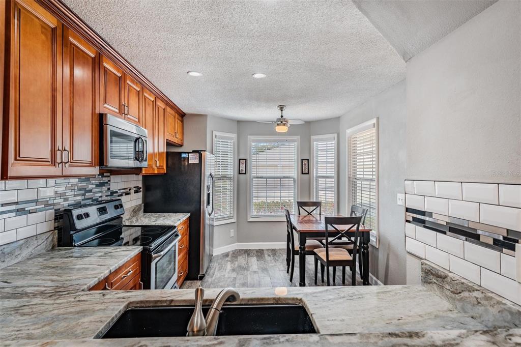 11308 Versailles Lane, Unit C Port Richey, FL 34668 - Photo 3 of 33 a kitchen with stainless steel appliances kitchen island granite countertop a sink and cabinets