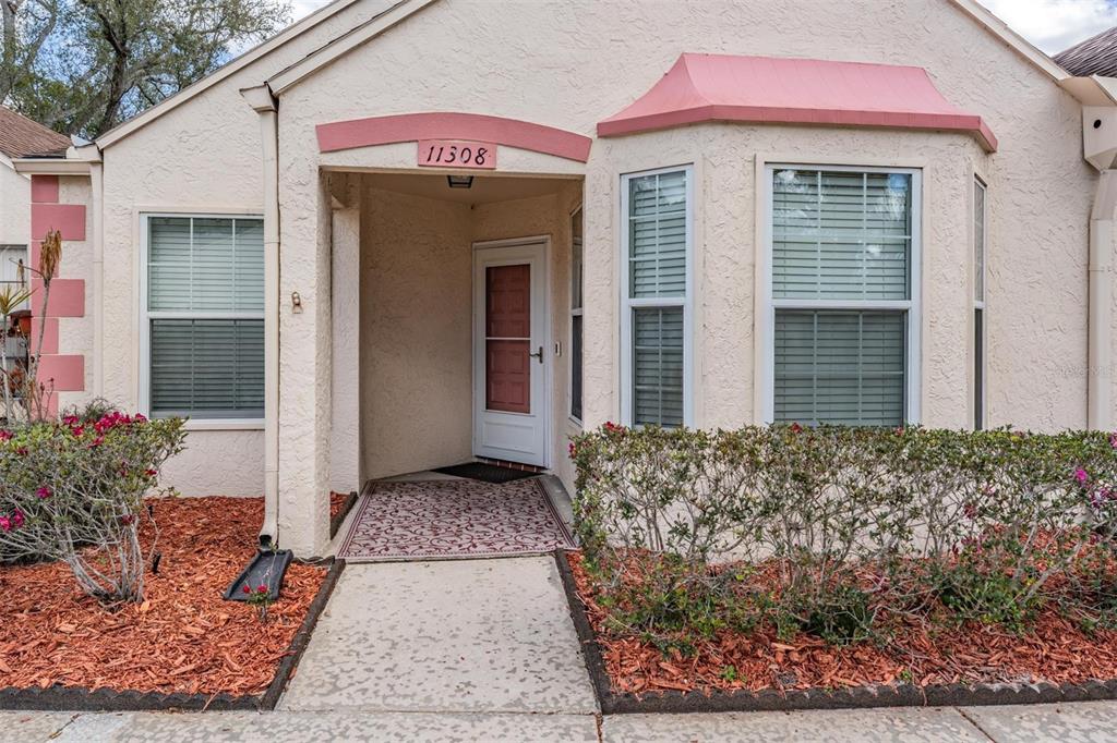11308 Versailles Lane, Unit C Port Richey, FL 34668 - Photo 31 of 33 a house view with a outdoor space