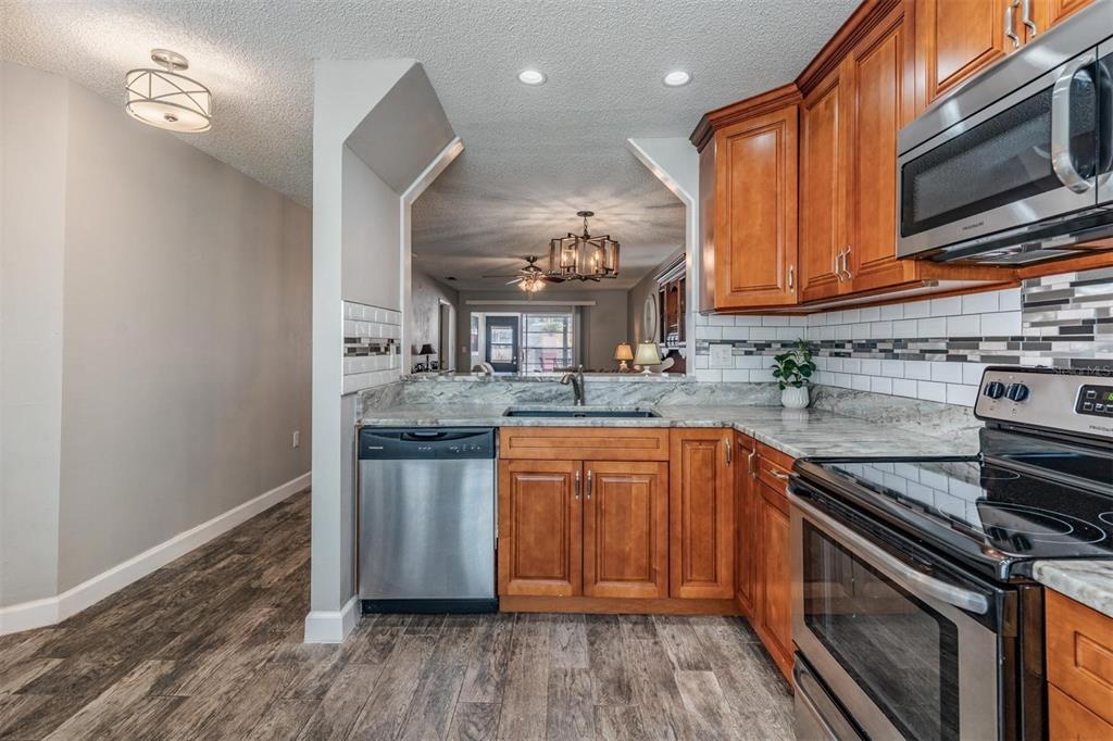 11308 Versailles Lane, Unit C Port Richey, FL 34668 - Photo 4 of 33 a kitchen with stainless steel appliances granite countertop a sink stove and refrigerator