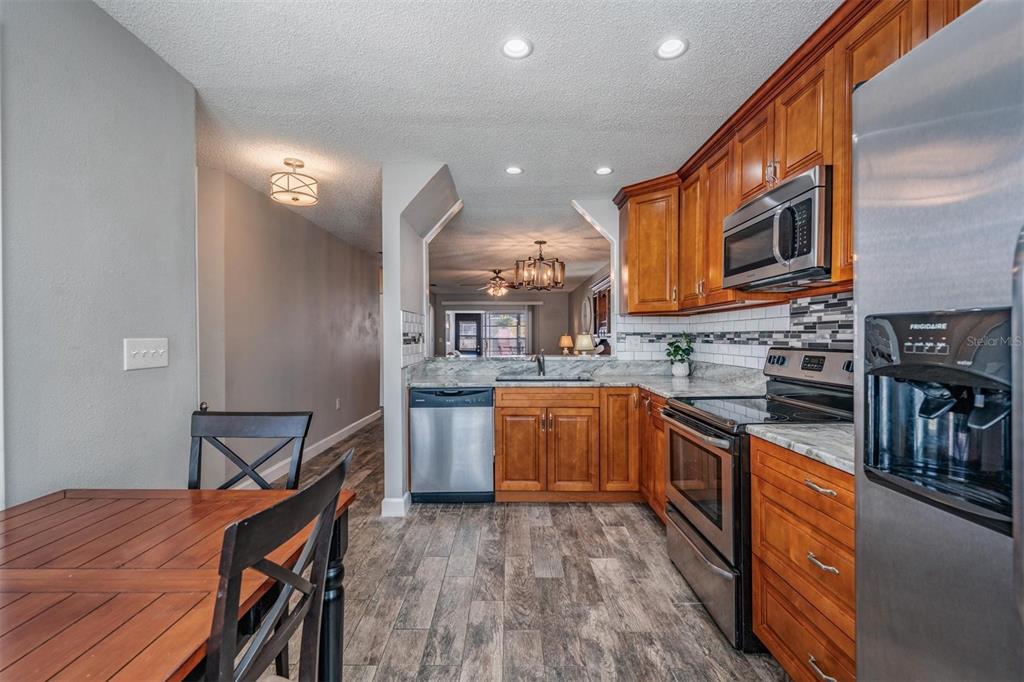 11308 Versailles Lane, Unit C Port Richey, FL 34668 - Photo 6 of 33 a kitchen with stainless steel appliances granite countertop a stove a sink dishwasher and a refrigerator