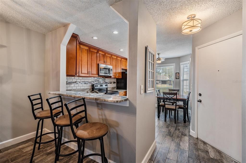 11308 Versailles Lane, Unit C Port Richey, FL 34668 - Photo 8 of 33 a kitchen with a dining table chairs and cabinets