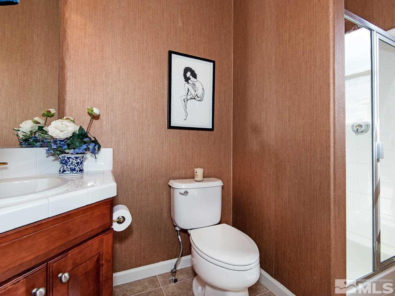 1635 Crater Court Reno, NV 89521 - Photo 13 of 25 a bathroom with a toilet a sink and mirror