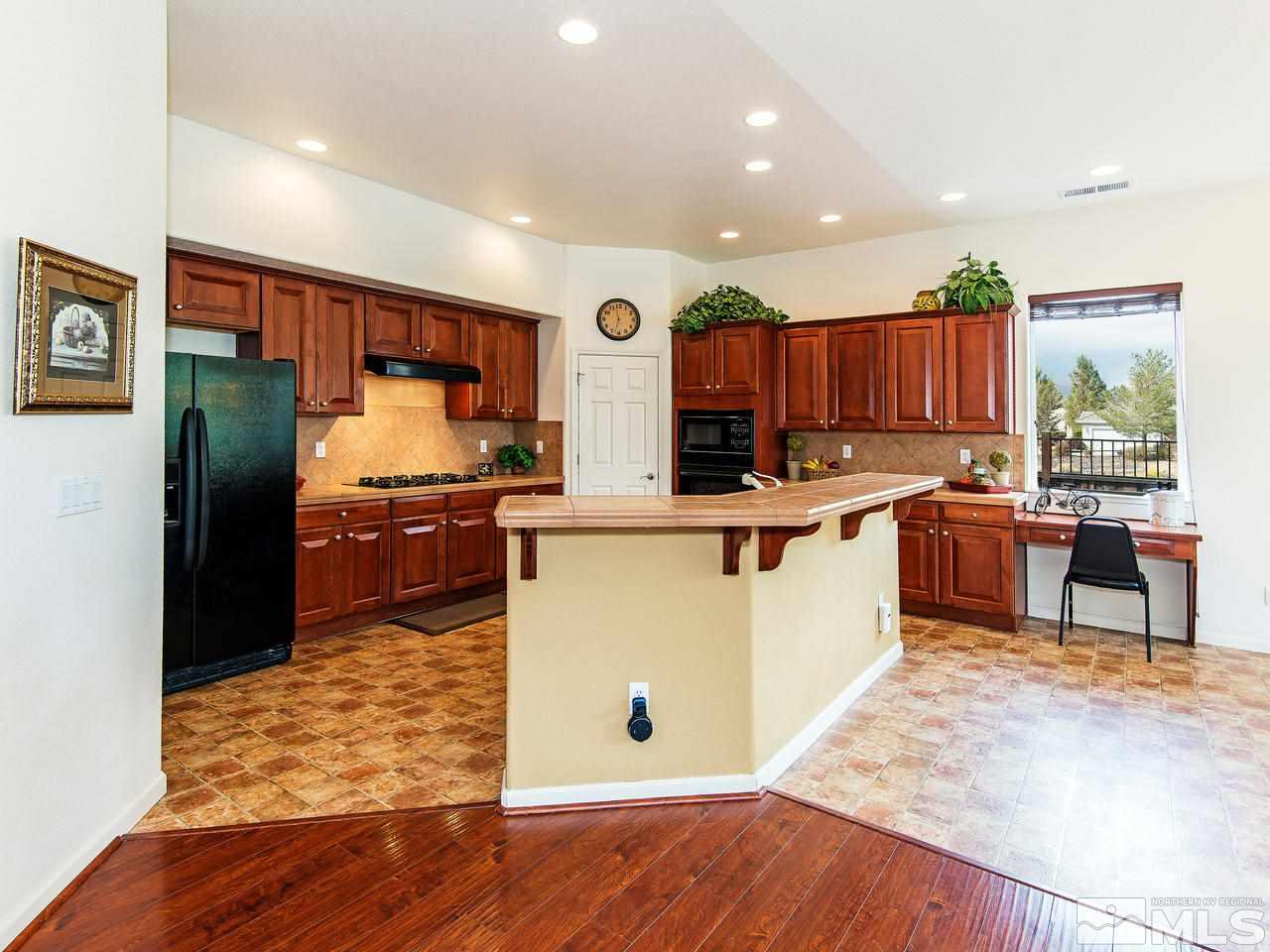 1635 Crater Court Reno, NV 89521 - Photo 7 of 25 a kitchen with stainless steel appliances granite countertop a refrigerator sink and wooden cabinets