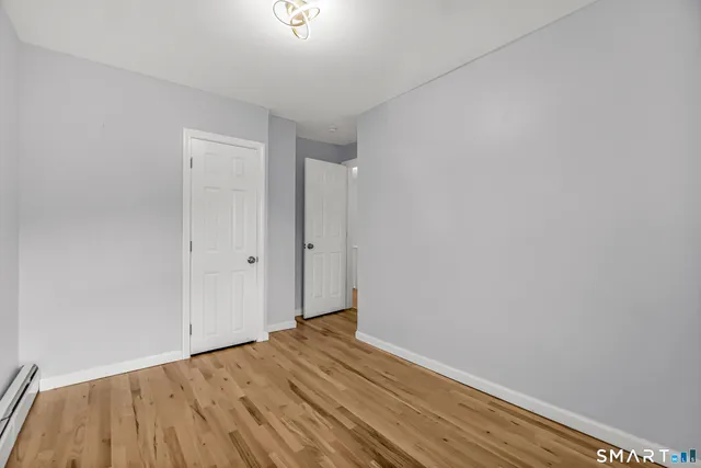 a view of empty room with wooden floor
