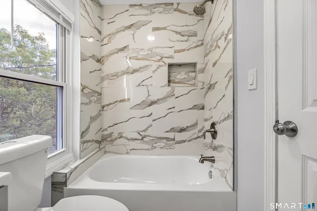 a bathroom with a bathtub and a toilet