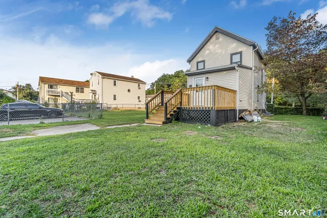 a view of a big house with a big yard and large trees