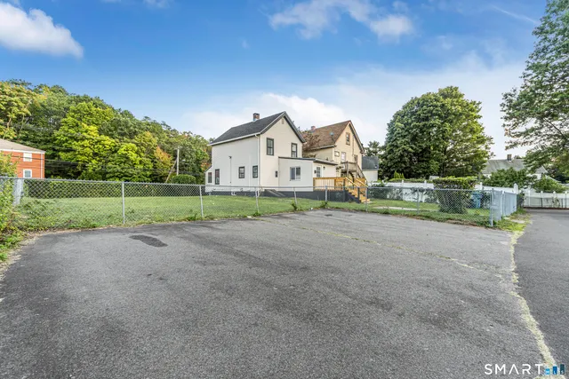 a view of a house with a big yard and large trees