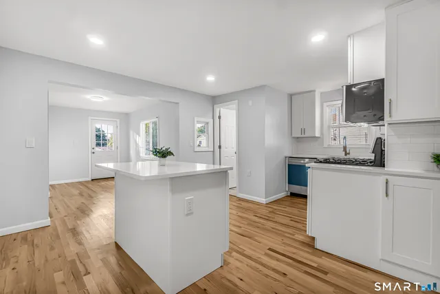 a kitchen with stainless steel appliances granite countertop a sink stove and microwave