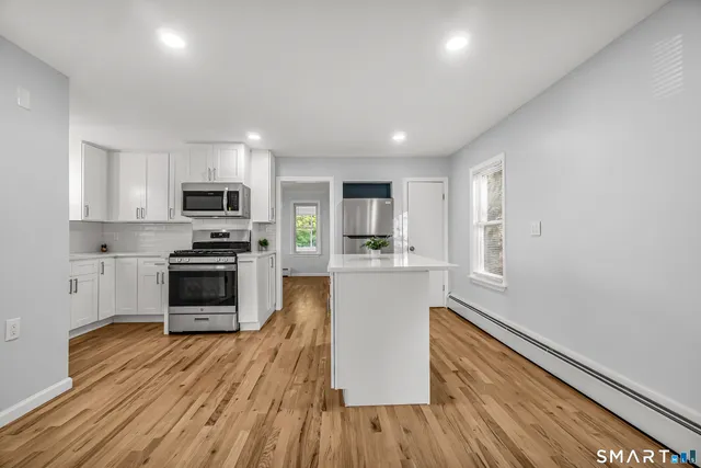 a kitchen with wooden floors a stove and a microwave