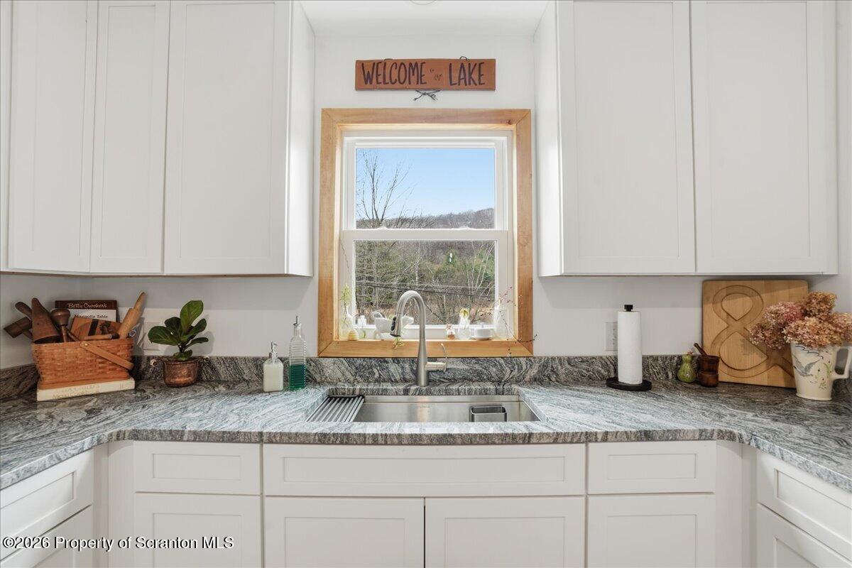 232 Starrucca Creek Road Starrucca, PA 18462 - Photo 19 of 64 a kitchen with granite countertop a sink a window and cabinets