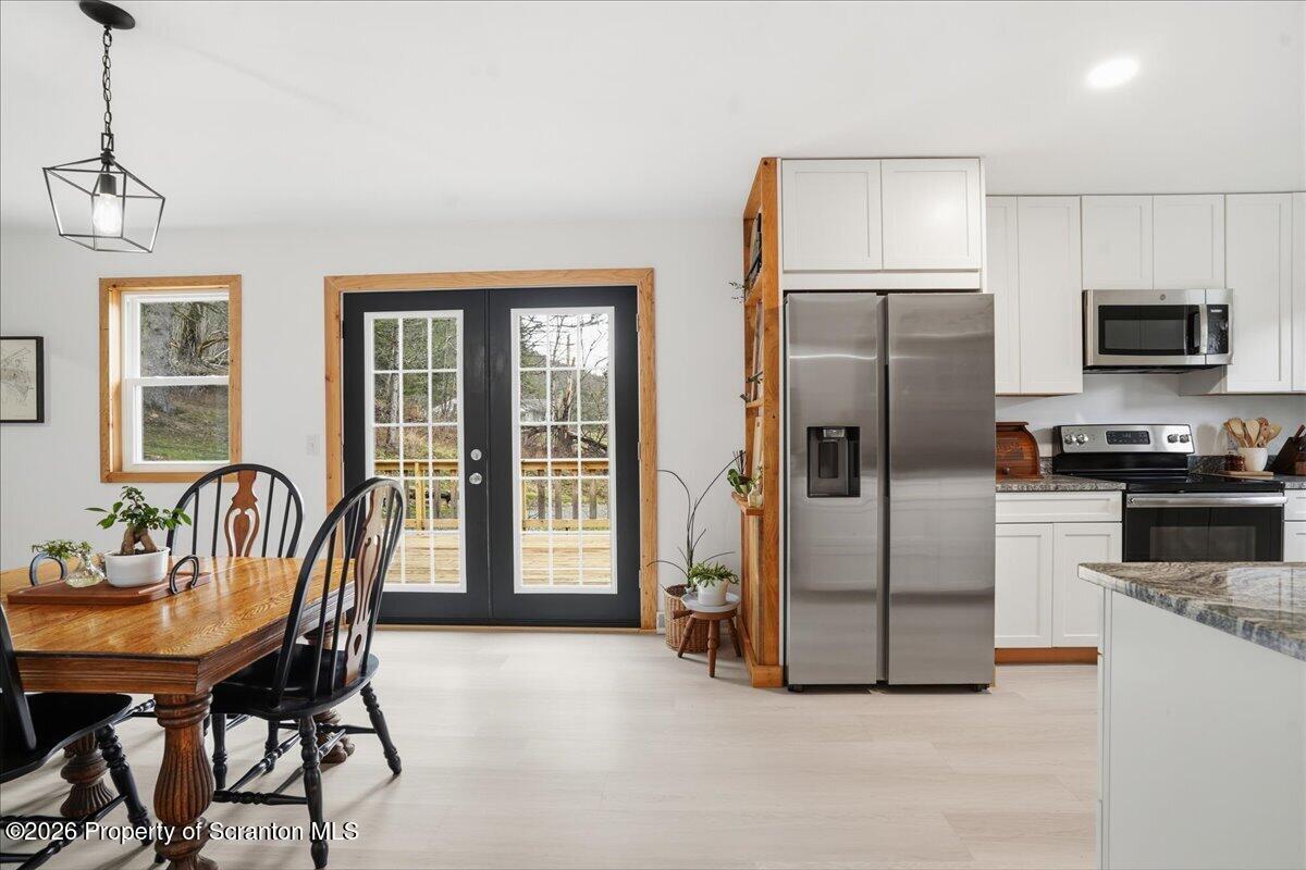 232 Starrucca Creek Road Starrucca, PA 18462 - Photo 22 of 64 a kitchen with stainless steel appliances granite countertop a refrigerator a stove a sink a dining table and chairs