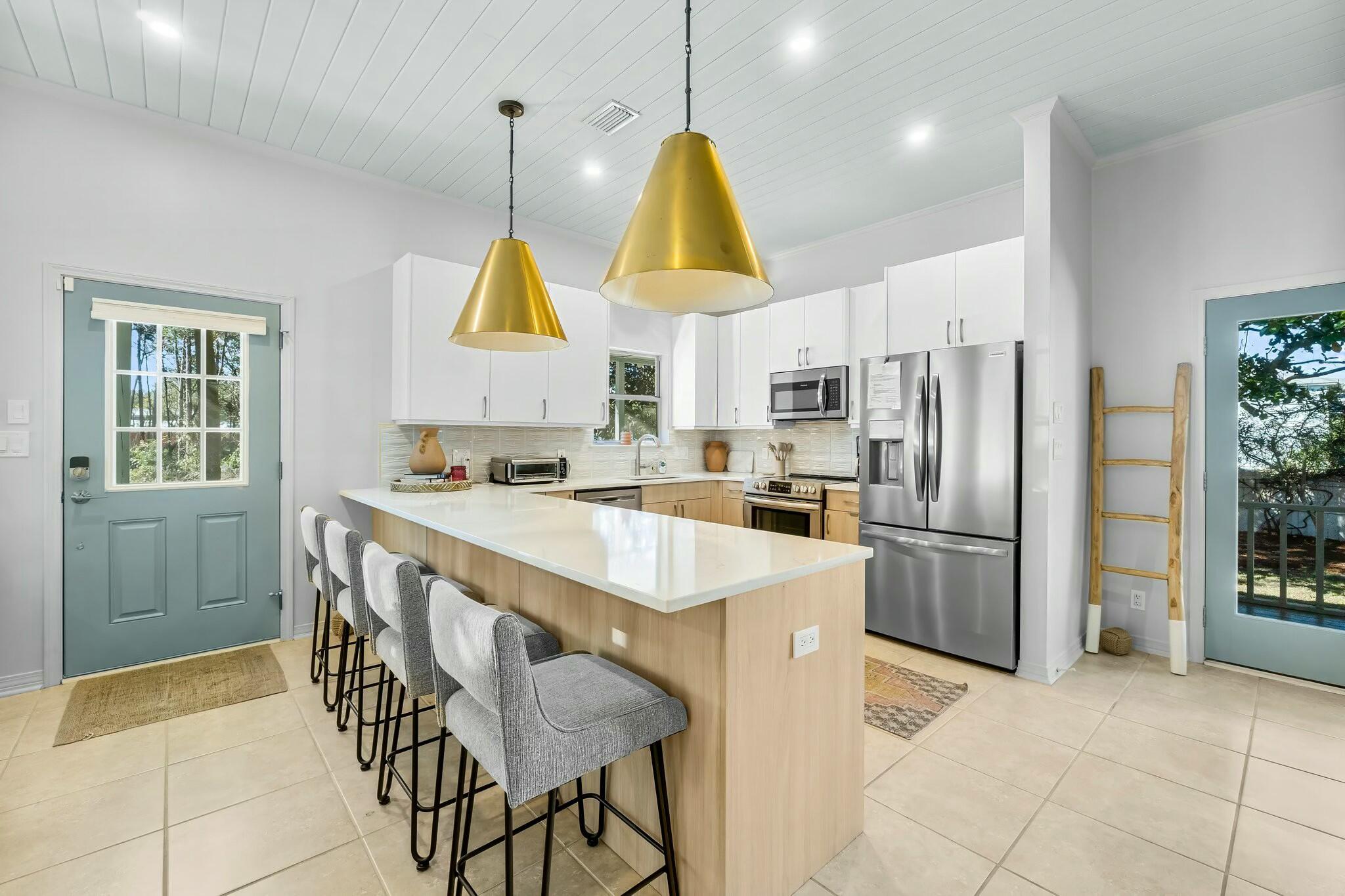 15 Maple Street Santa Rosa Beach, FL 32459 - Photo 6 of 34 a kitchen with kitchen island white cabinets and stainless steel appliances