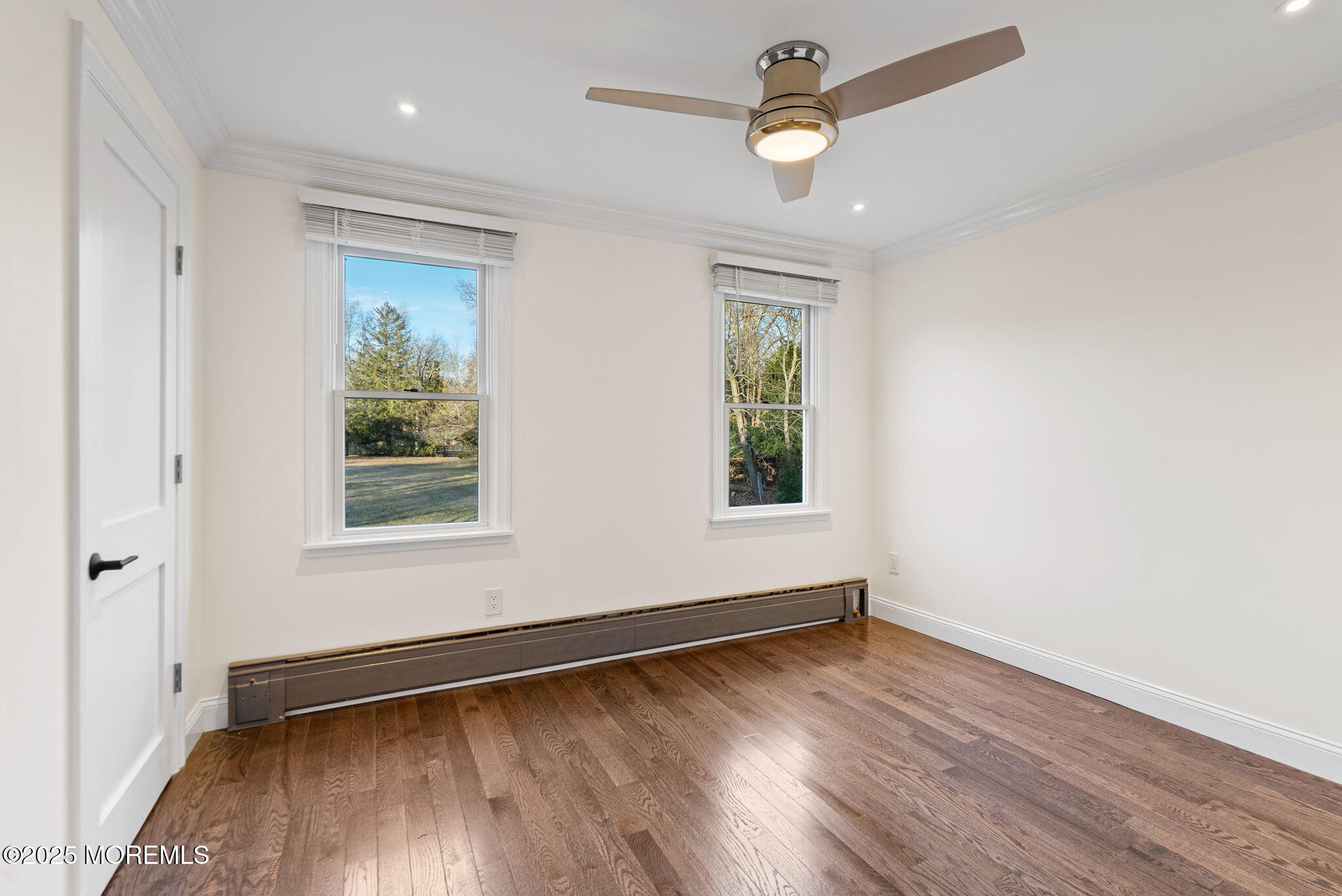 458 Newtons Corner Road Howell, NJ 07731 - Photo 33 of 44 an empty room with wooden floor ceiling fan and windows