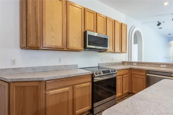 a kitchen with stainless steel appliances granite countertop a sink a stove a microwave oven with cabinets and wooden floor