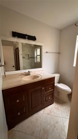 a bathroom with a sink vanity and a toilet